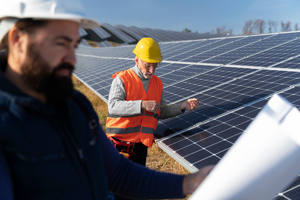 rentabilite-panneaux-solaires Technicien réalisant la maintenance de panneaux solaires dans une centrale photovoltaïque pour améliorer la rentabilité énergétique et la production d’électricité renouvelable.